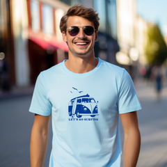 Man wearing a light blue t-shirt with a graphic design and text, standing on a street.