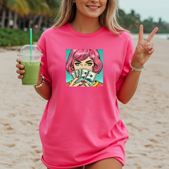 Woman on a beach wearing a pink t-shirt with a graphic design, holding a green drink.