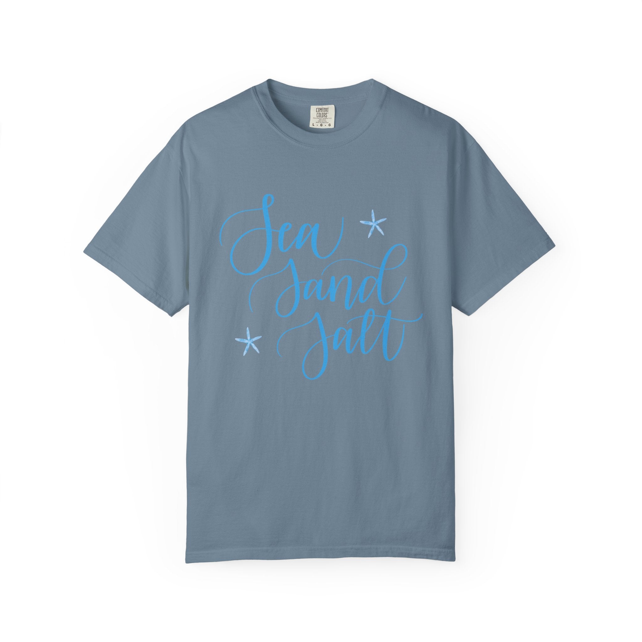 Blue t-shirt with 'Sea Sand Salt' text on a white background