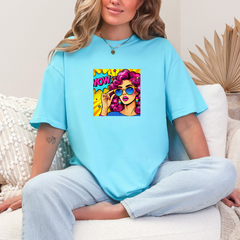 Person wearing a light blue t-shirt with a colorful graphic design sitting on a white couch.