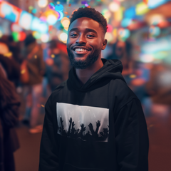 Man wearing a black hoodie with a graphic design, standing in a vibrant, colorful street scene.