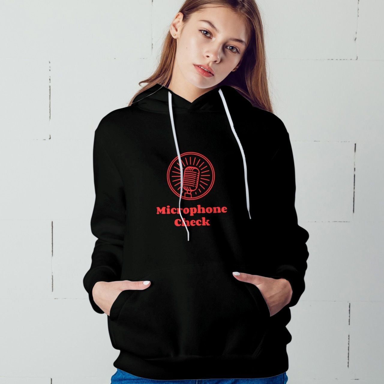 Person wearing a black hoodie with a red microphone graphic and text against a white background
