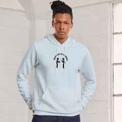 Person wearing a light blue hoodie with a graphic design in a white room.