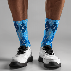 Blue argyle socks worn with white sneakers on a gray background