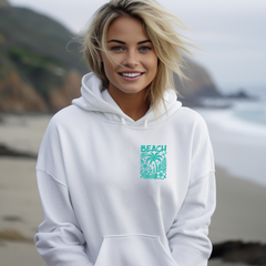 A female model wearing a white beach vibes hoodie at the beach