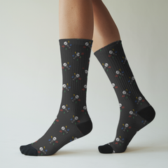 Black socks with colorful pattern of microphones worn by a person on a light background