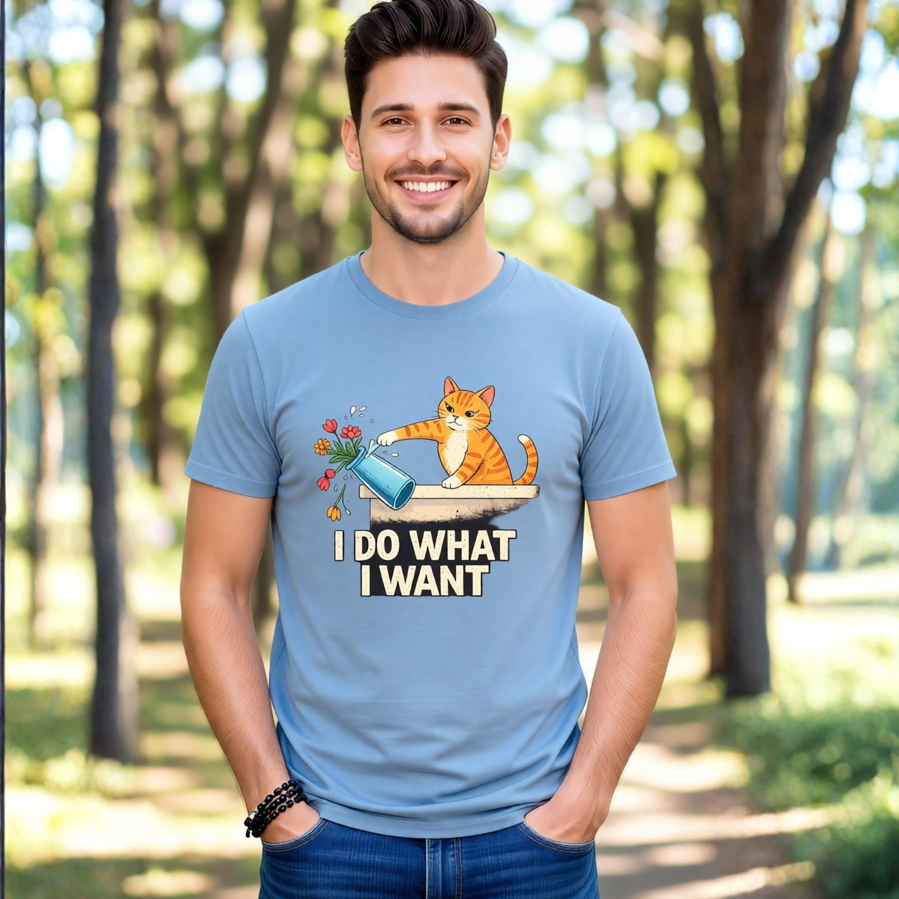 Man wearing a blue t-shirt with a cat graphic and text in a park