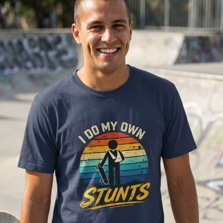 Man wearing a t-shirt with 'I do my own stunts' graphic at a skate park.