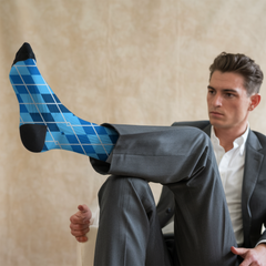 Man wearing blue argyle socks with a beige background