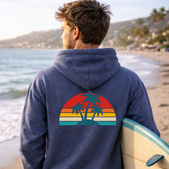 Man wearing a blue hoodie with a palm tree design on a beach