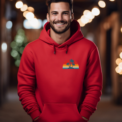 Man wearing a red hoodie with a palm tree design in a festive setting