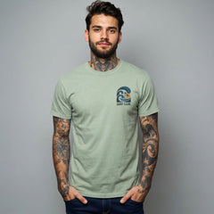 Man wearing a green t-shirt with a surf club logo on a gray background