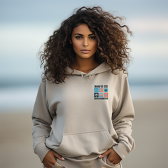 Woman wearing a beige hoodie with a graphic design on a beach
