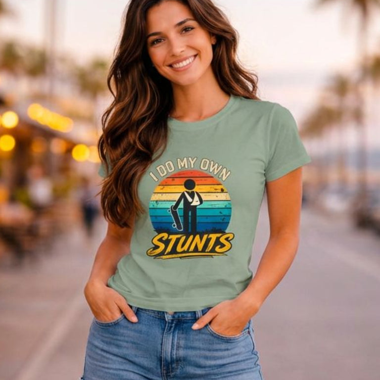 Woman on a skateboard wearing a t-shirt with 'My Own Stunts' graphic.