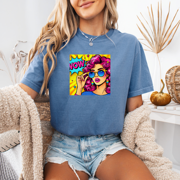 Person wearing a blue t-shirt with a colorful graphic design sitting on a couch.