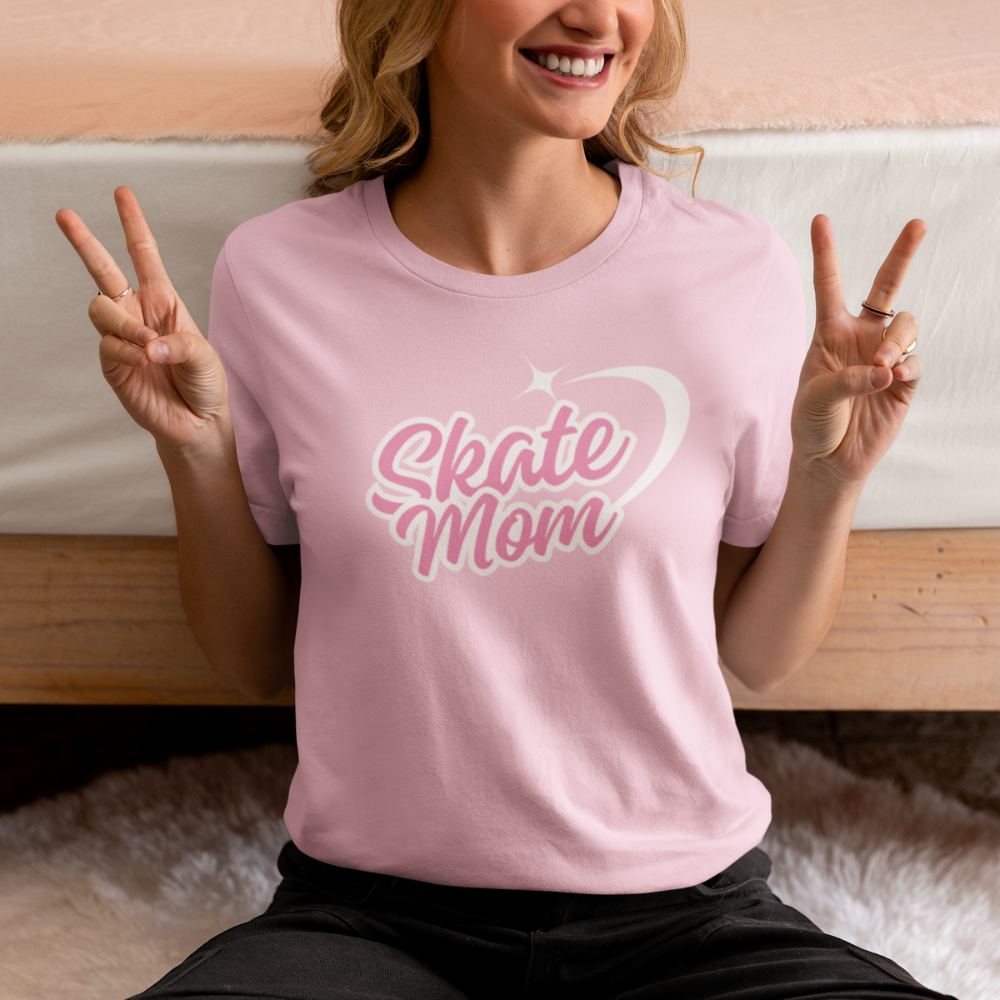 Woman wearing a pink 'Skate Mom' t-shirt, making peace signs.