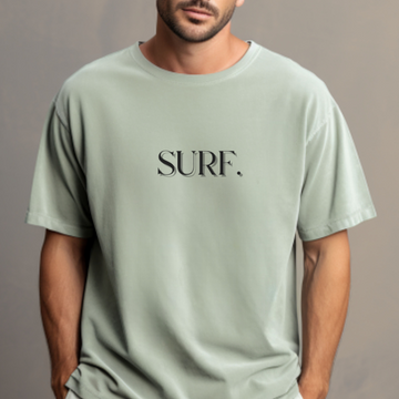 Person wearing a light green t-shirt with 'SURF.' text on a gray background