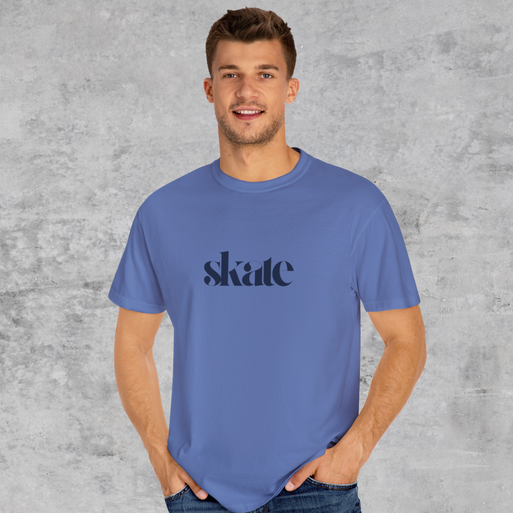 Man wearing a blue t-shirt with 'skate' printed on it against a gray background