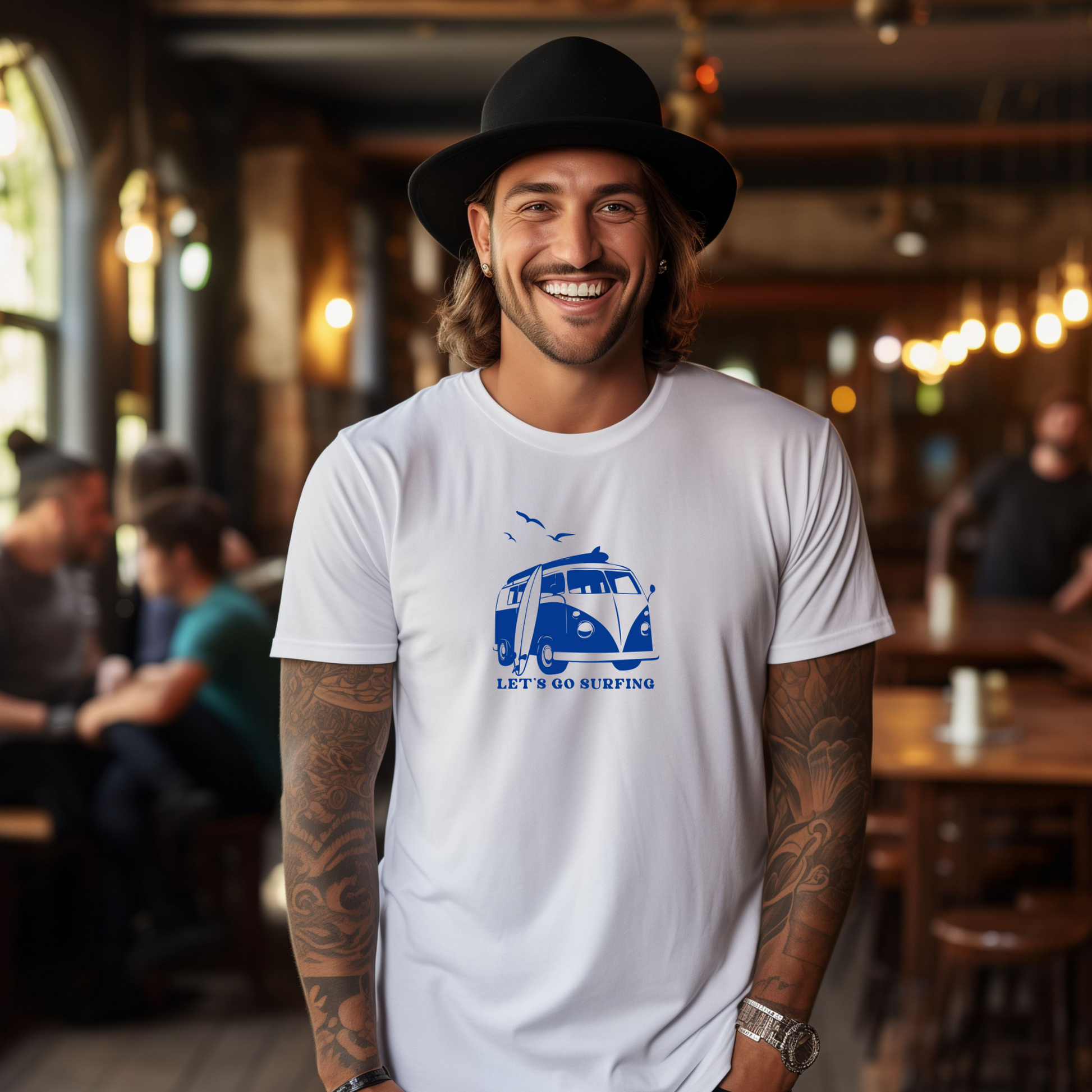 Man wearing a white t-shirt with a blue graphic and text, standing in a bar.