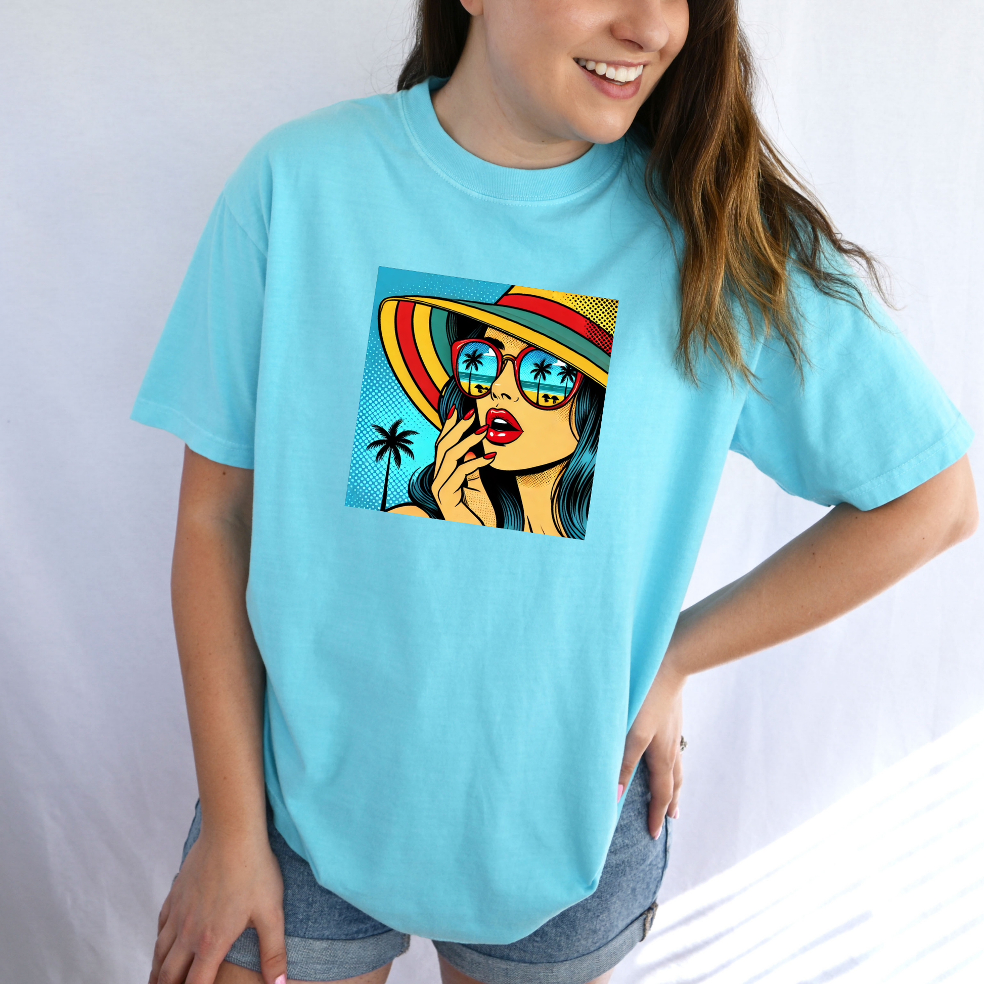 Person wearing a light blue t-shirt with a colorful graphic design on a plain background