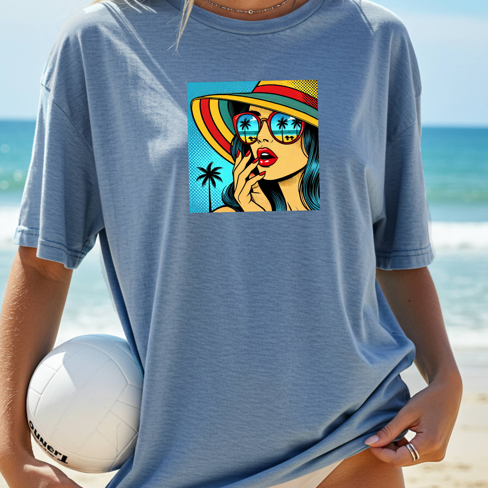 Person wearing a blue t-shirt with a colorful graphic of a woman on a beach.