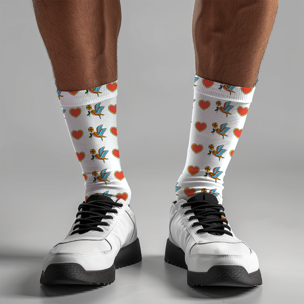 White socks with colorful designs worn by a person on a gray background