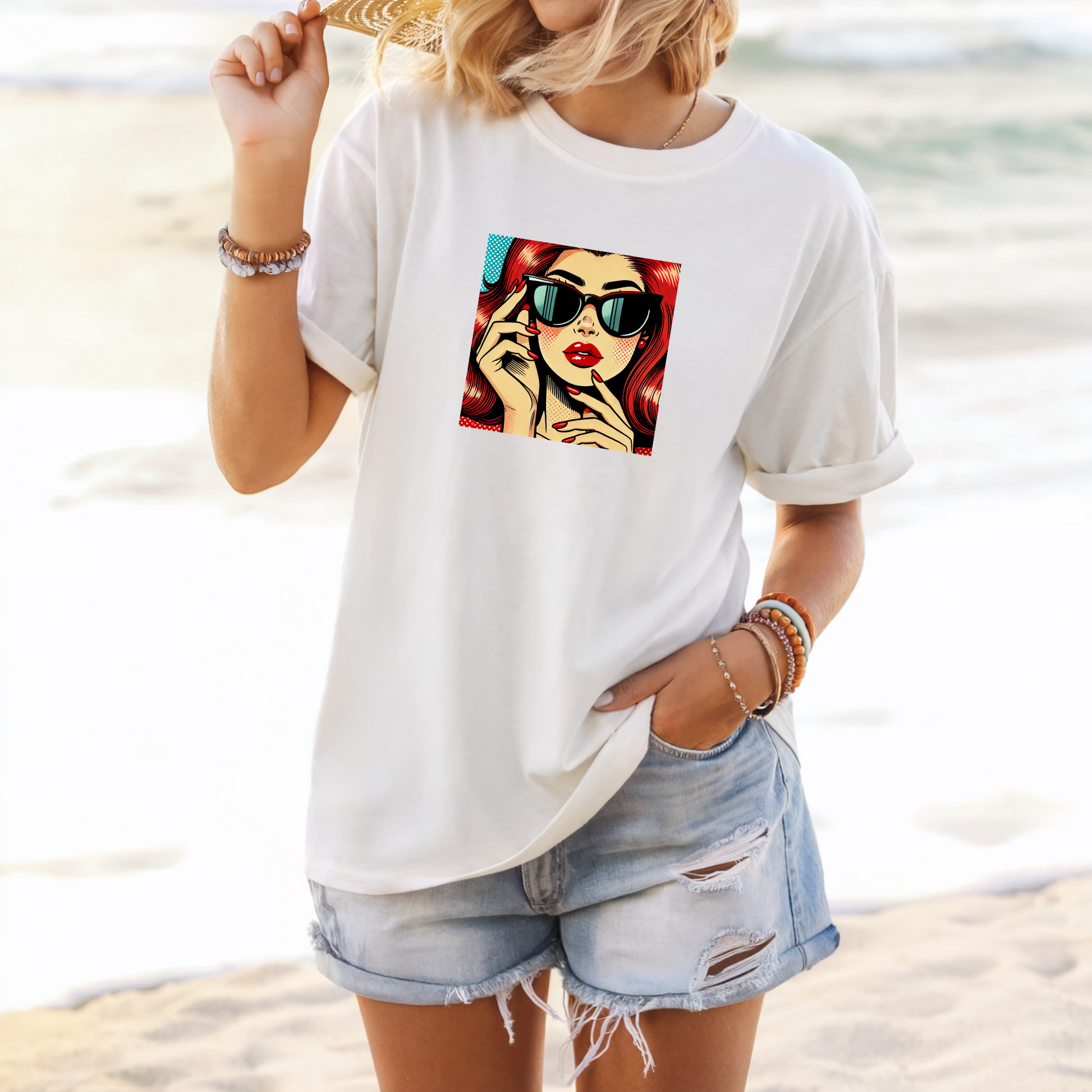 Person wearing a white t-shirt with a graphic design on a beach