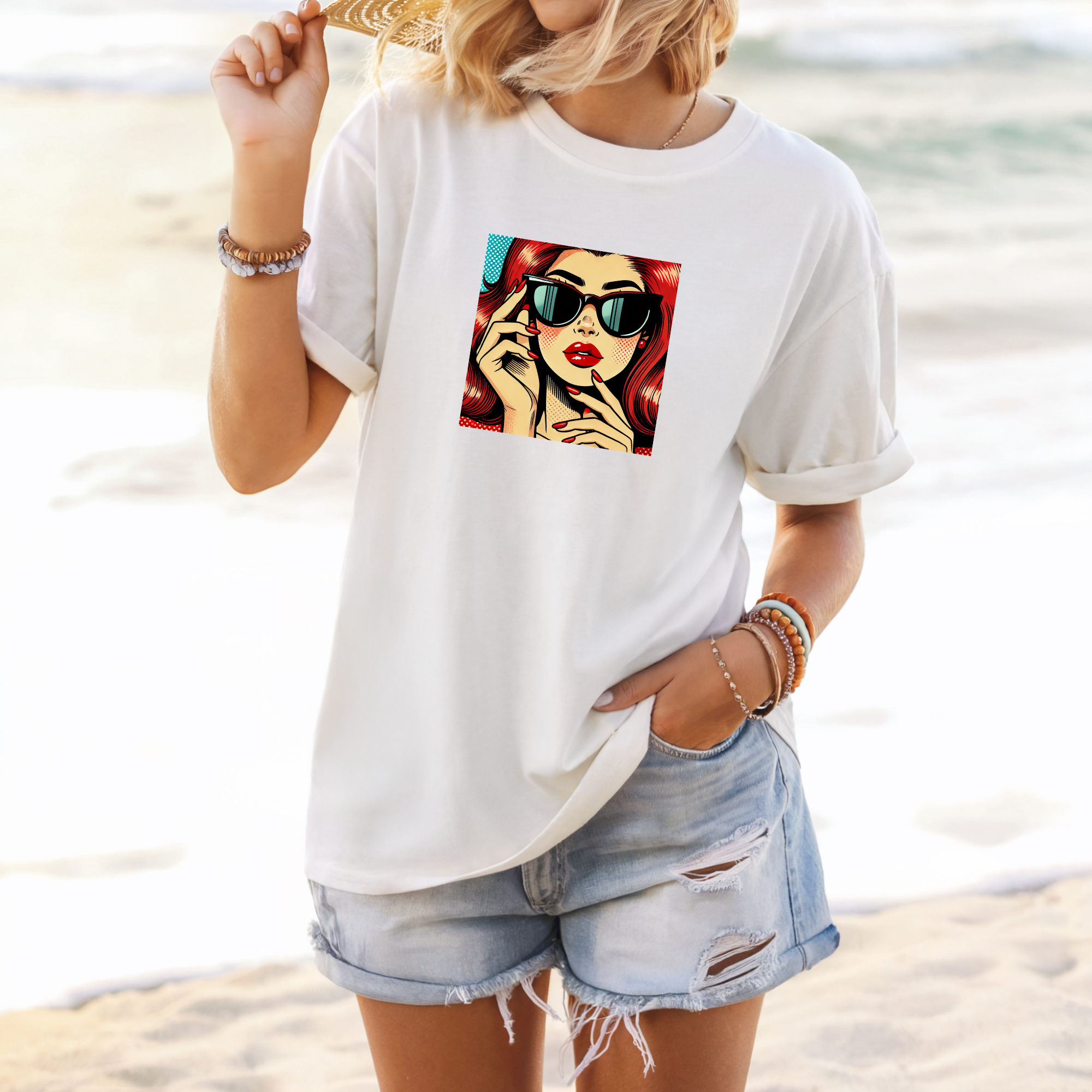 Person wearing a white t-shirt with a graphic design on a beach