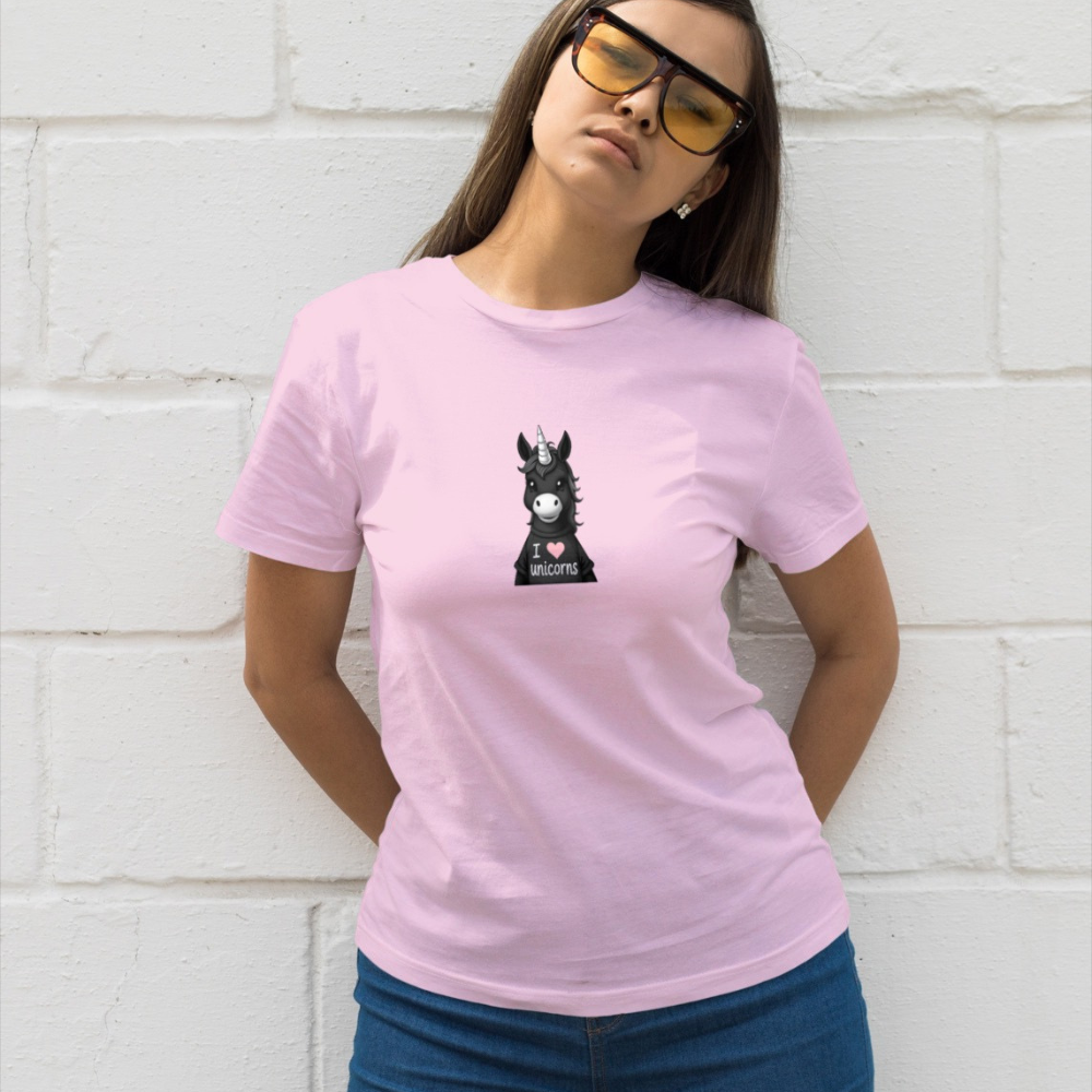 Woman wearing a pink t-shirt with a graphic design against a white brick wall.