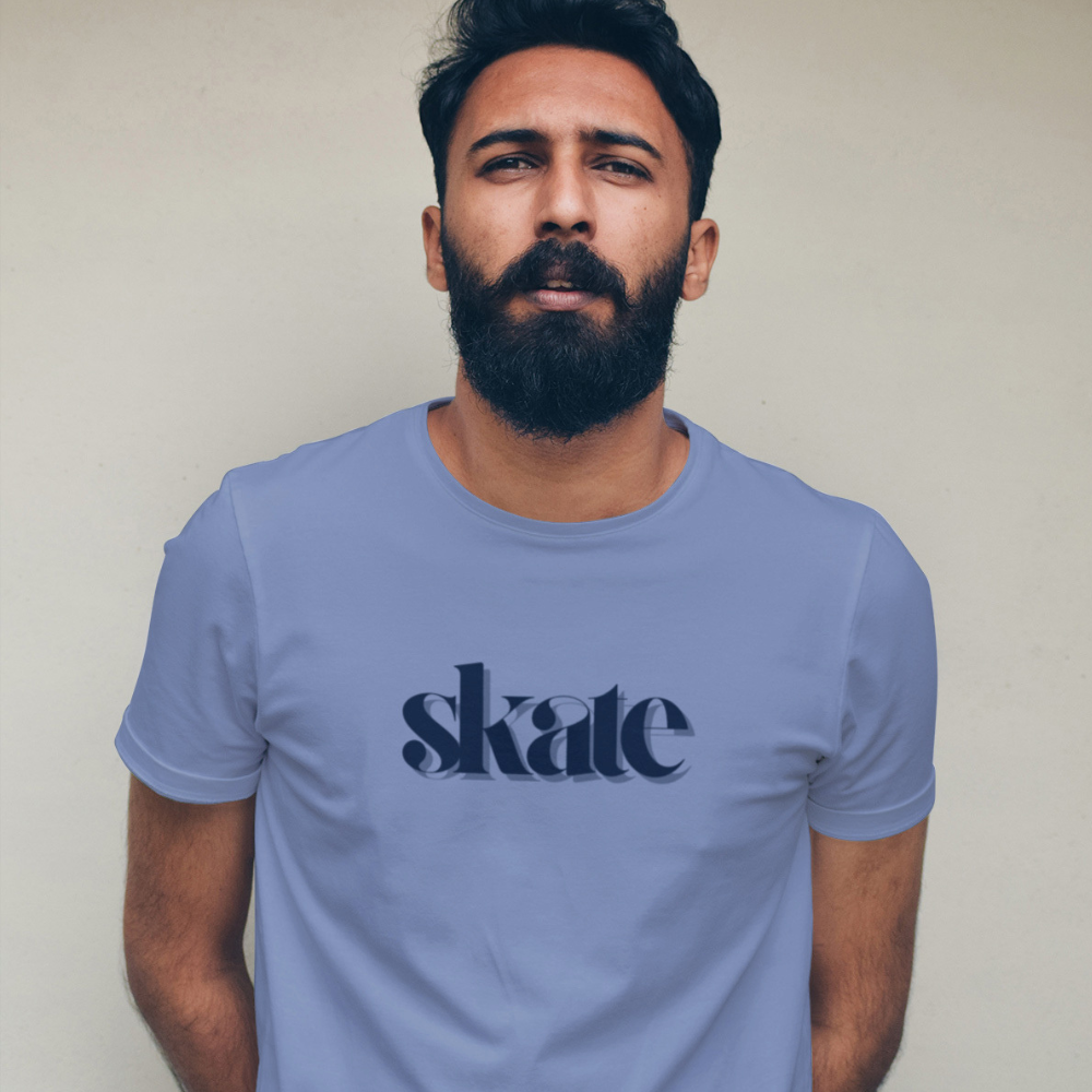 Man wearing a light blue t-shirt with 'skate' printed on it against a plain background