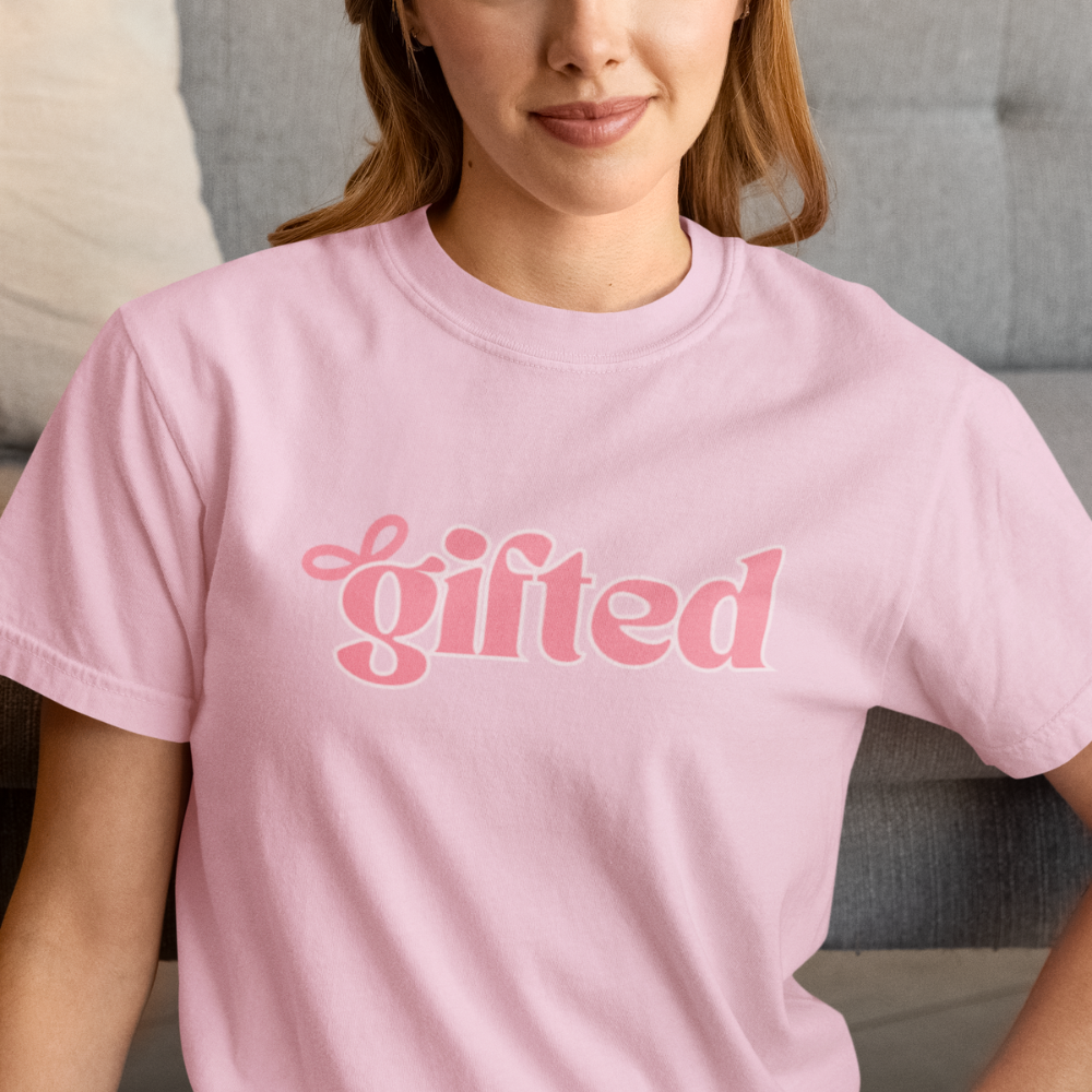 Person wearing a pink t-shirt with the word 'gifted' printed on it.