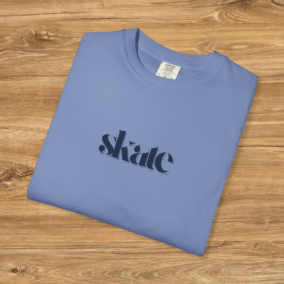 Man wearing a blue t-shirt with 'skate' printed on it against a gray background