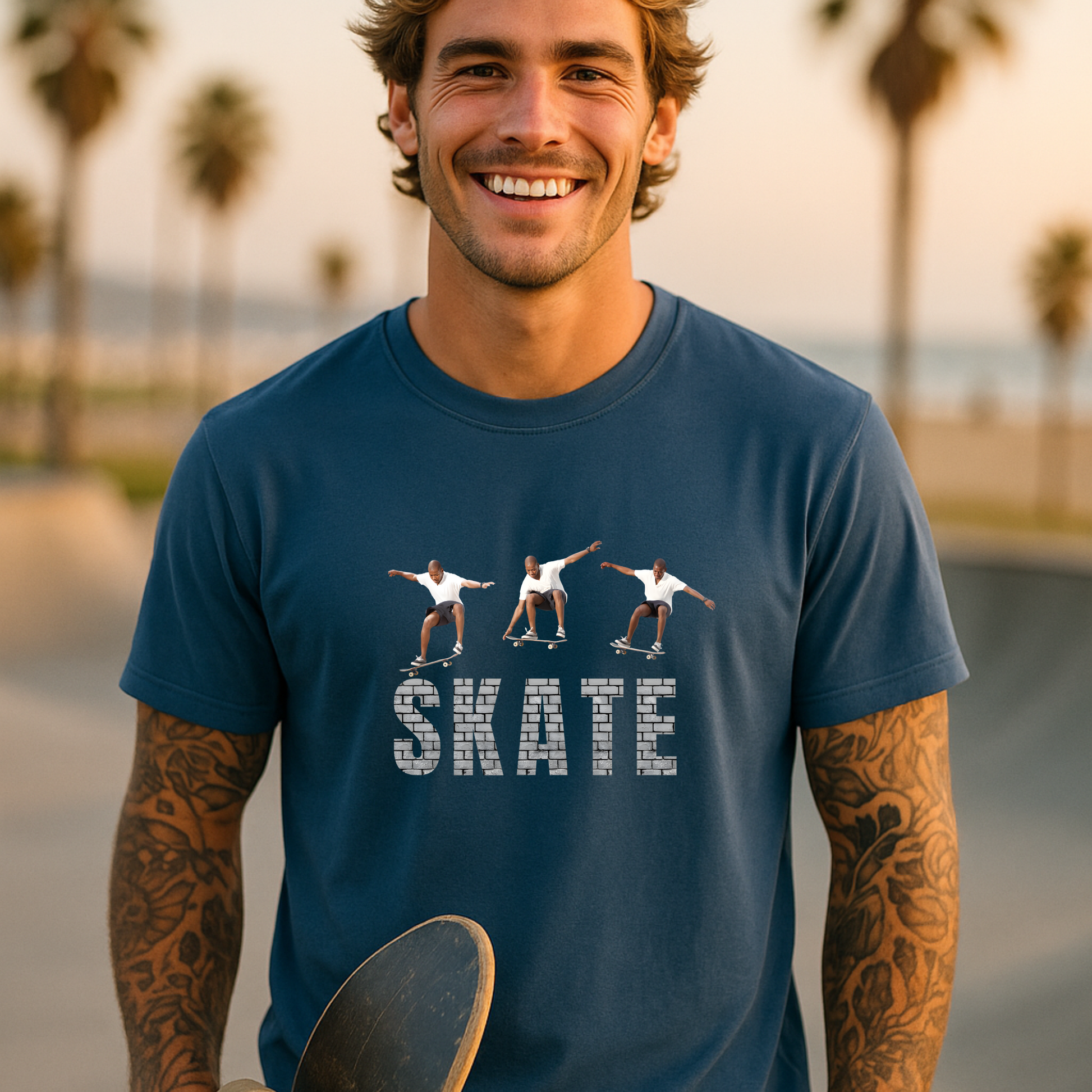 Man wearing a blue t-shirt with 'SKATE' and skateboard graphics at a skate park.