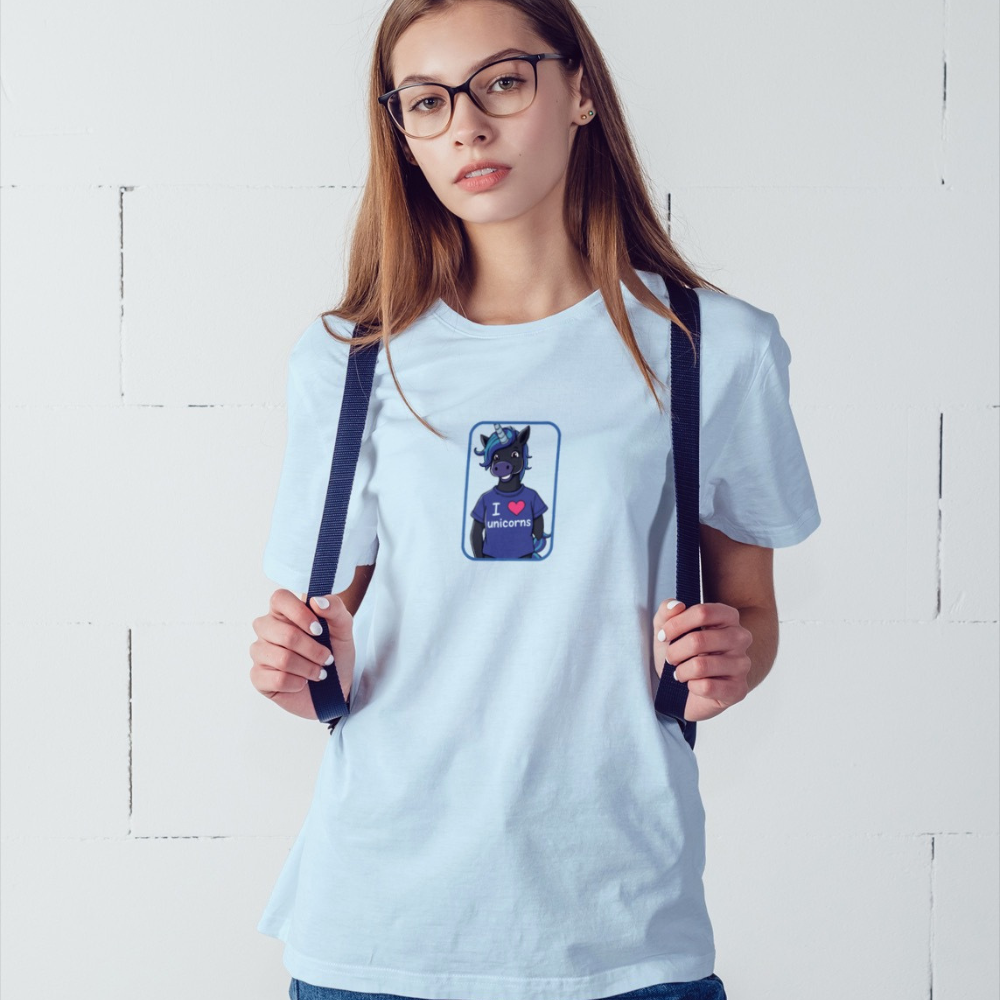 Person wearing a light blue t-shirt with a graphic design, standing against a white wall.