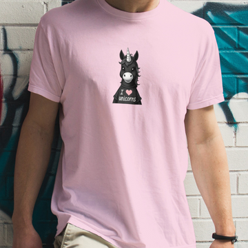 Person wearing a pink t-shirt with a graphic of a donkey unicorn and 'I love unicorns' text, standing against a graffiti-covered wall.