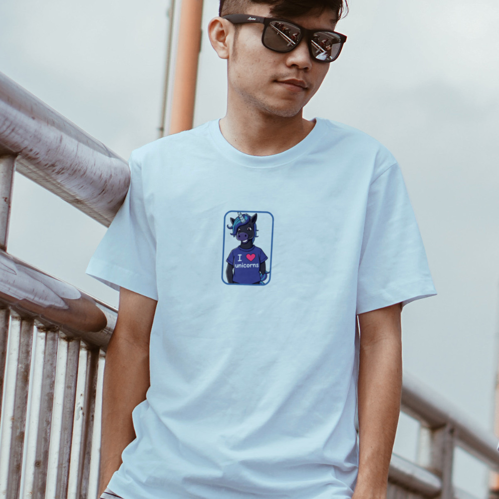 Person wearing a light blue t-shirt with a graphic design, standing outdoors.