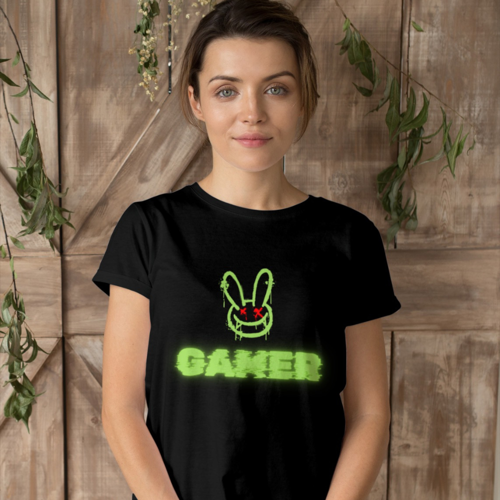 Woman wearing a black t-shirt with a green graphic and 'Gamer' text against a wooden background