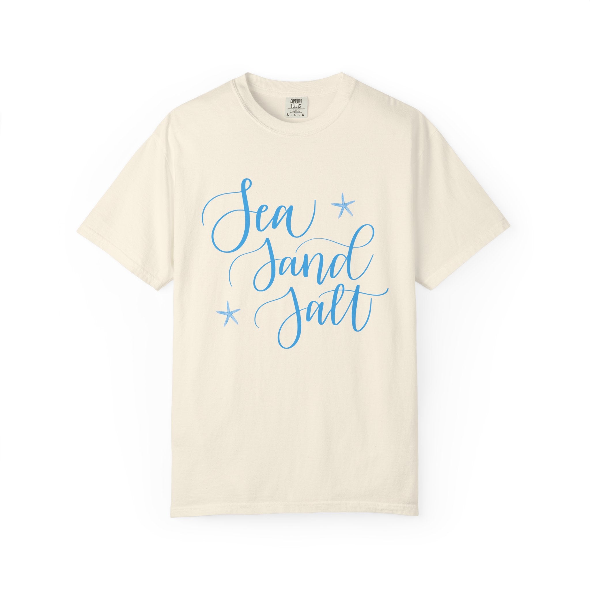Beige t-shirt with 'Sea Sand Salt' text in blue on a white background