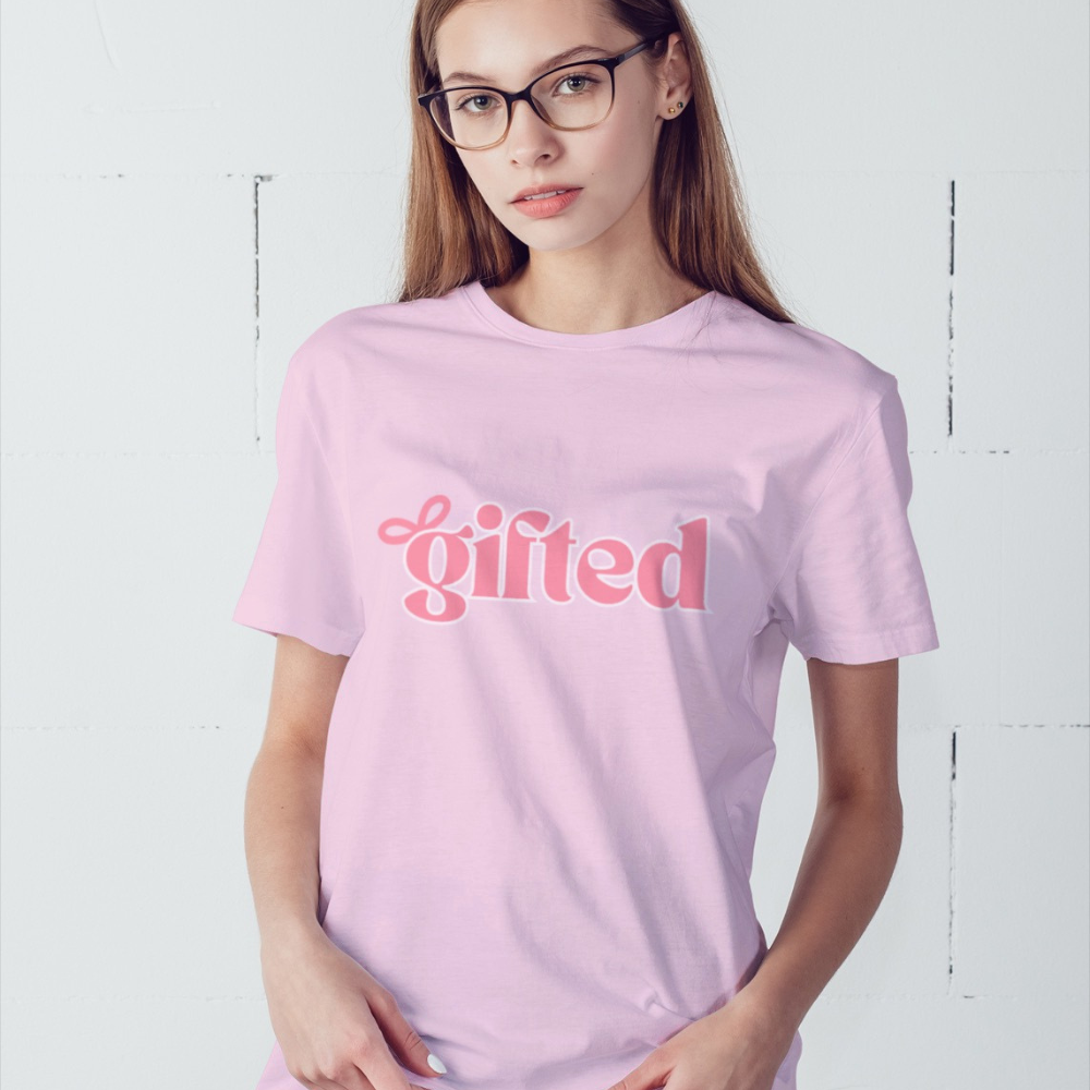 Person wearing a pink t-shirt with 'gifted' text on a white background