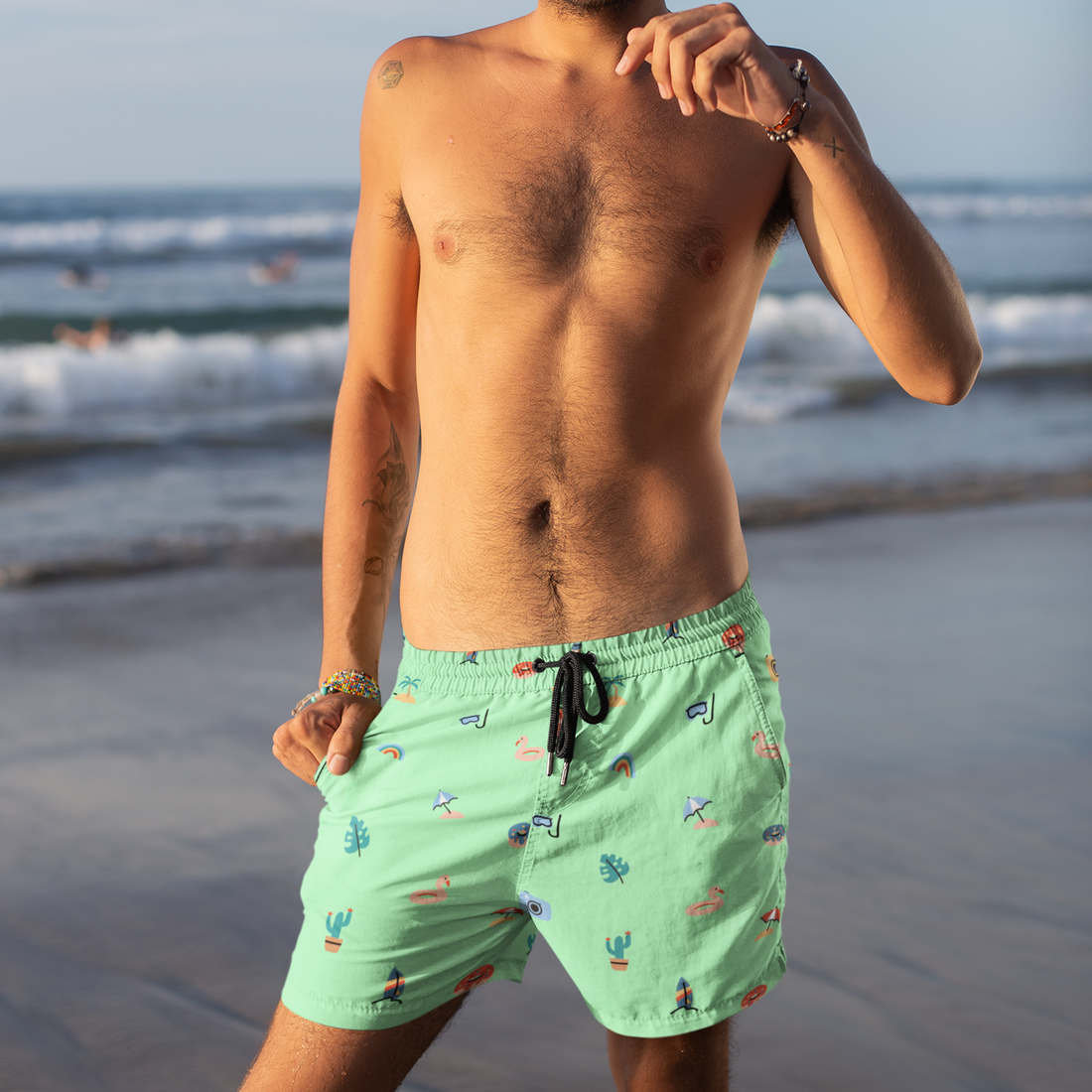 Green swim shorts with colorful patterns on a white background