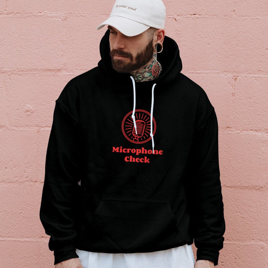 Person wearing a black hoodie with a red logo and text in a dark setting