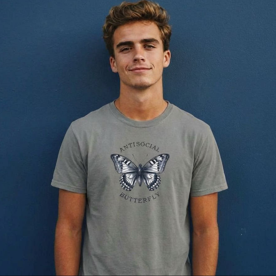 Person wearing a gray t-shirt with a butterfly graphic and text against a blue background