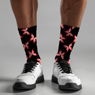 Black socks with red butterfly pattern worn with white sneakers on a gray background