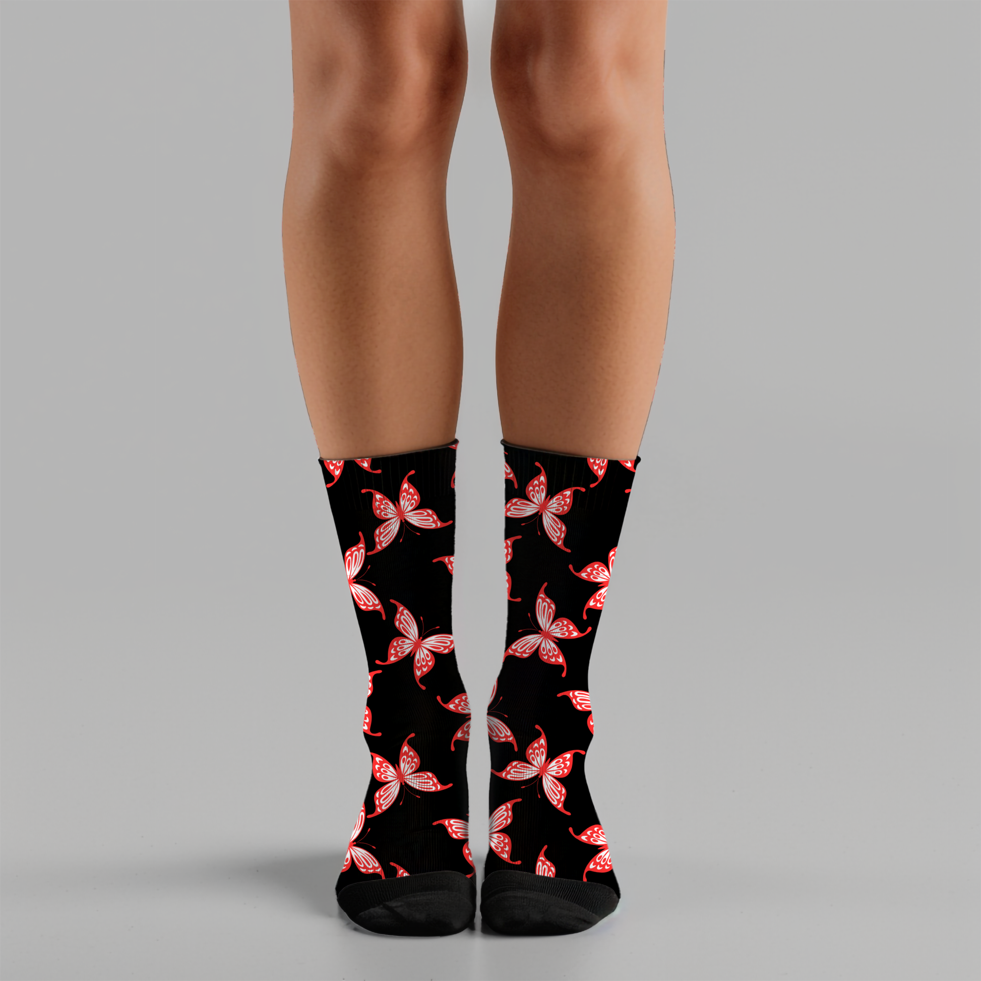 Black socks with red and white butterfly pattern worn by a person on a gray background