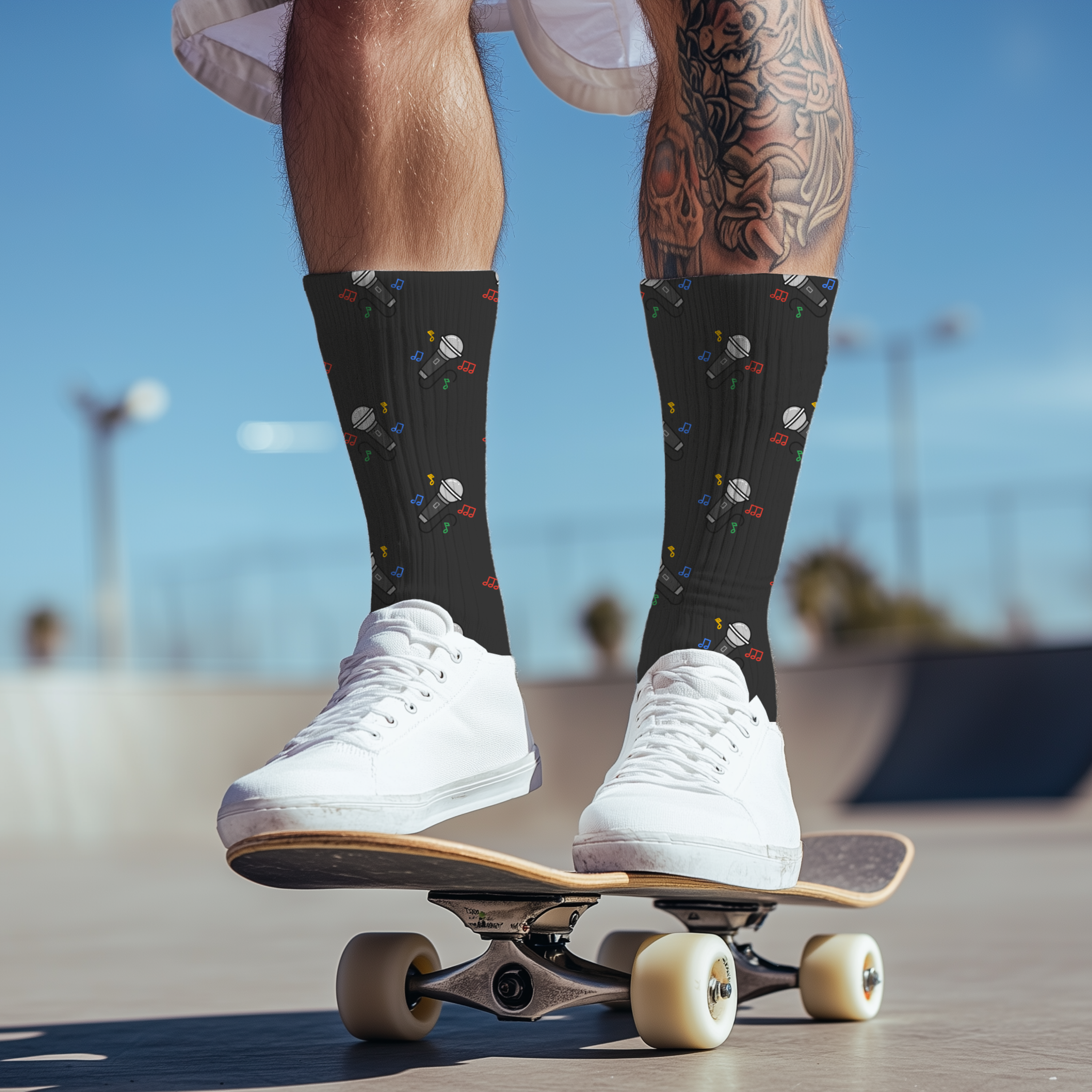 Person wearing black socks with a pattern of microphones and white sneakers on a skateboard.