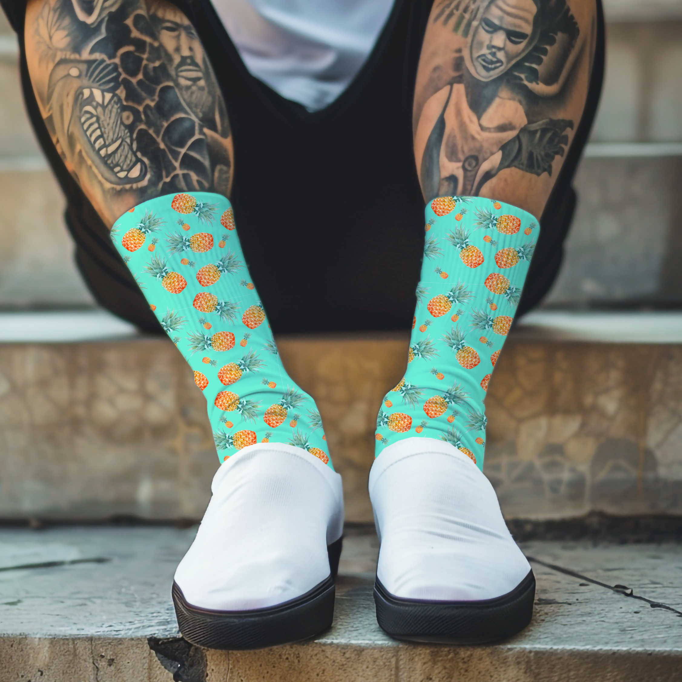 Person wearing teal socks with pineapple pattern and white shoes sitting on steps.