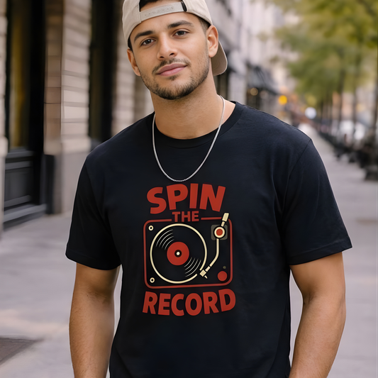 Man wearing a black t-shirt with 'Spin the Record' design on a city street.