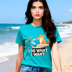 Woman wearing a teal t-shirt with a cat graphic and text on a beach