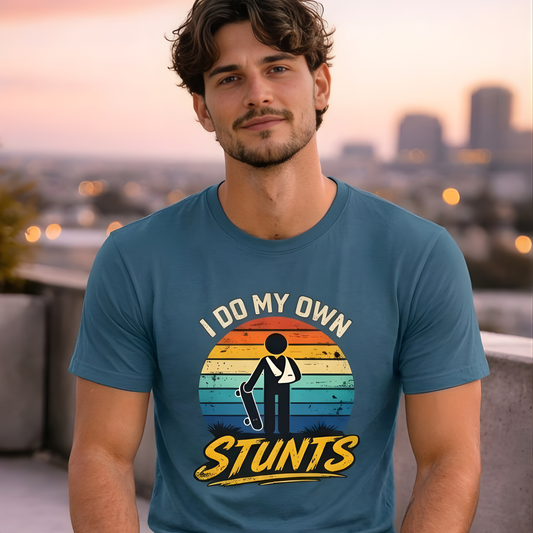 Man wearing a blue t-shirt with 'I Do My Own Stunts' graphic design, standing on a rooftop with a cityscape background.