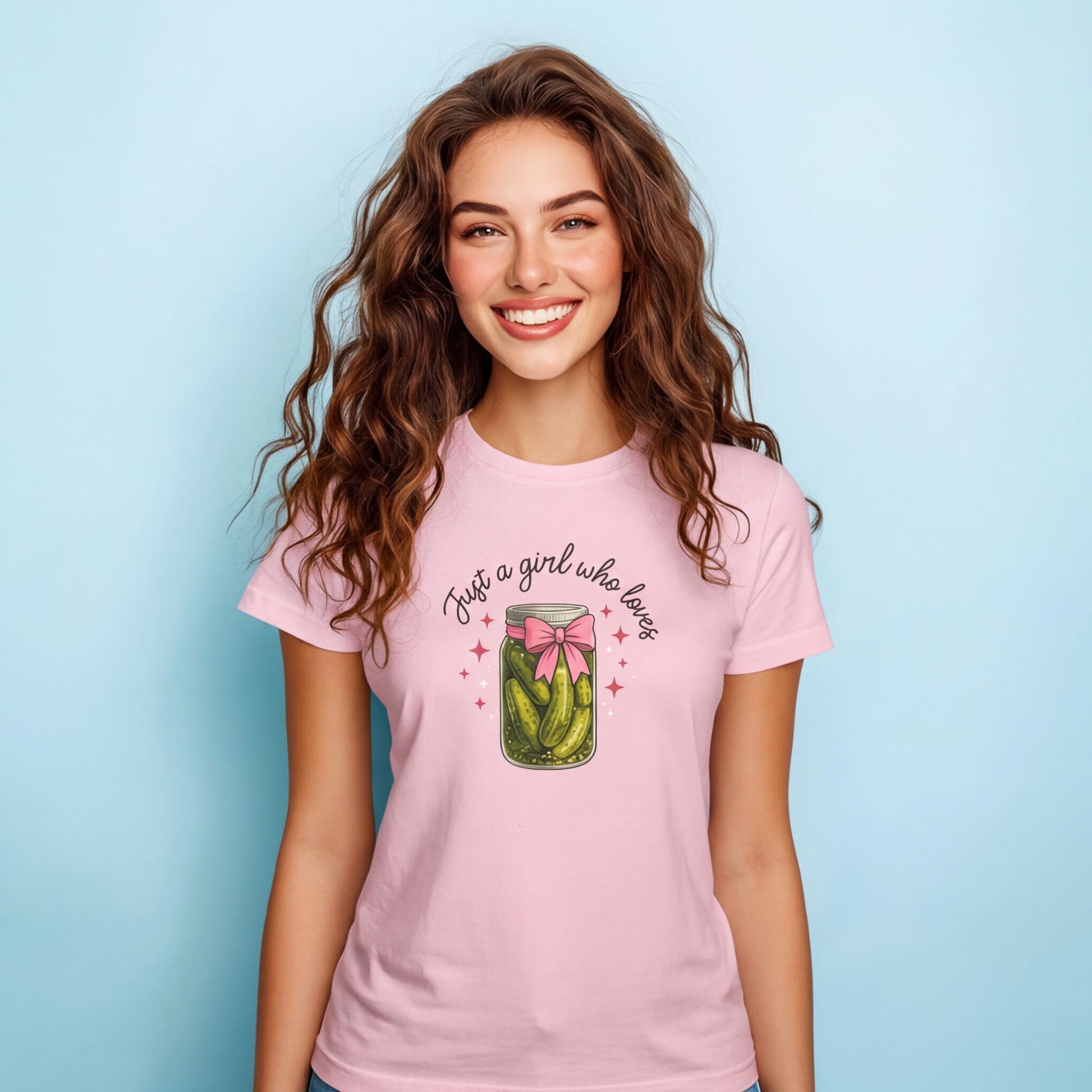 Woman wearing a pink t-shirt with a graphic and text on a light blue background
